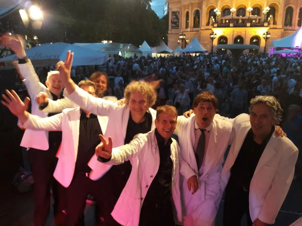 Die Band in weißen Sakkos jubelt am Abend vor großem Publikum